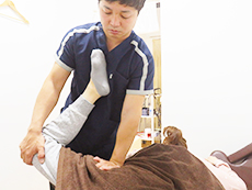 患者さんの足を股関節から持ち上げる